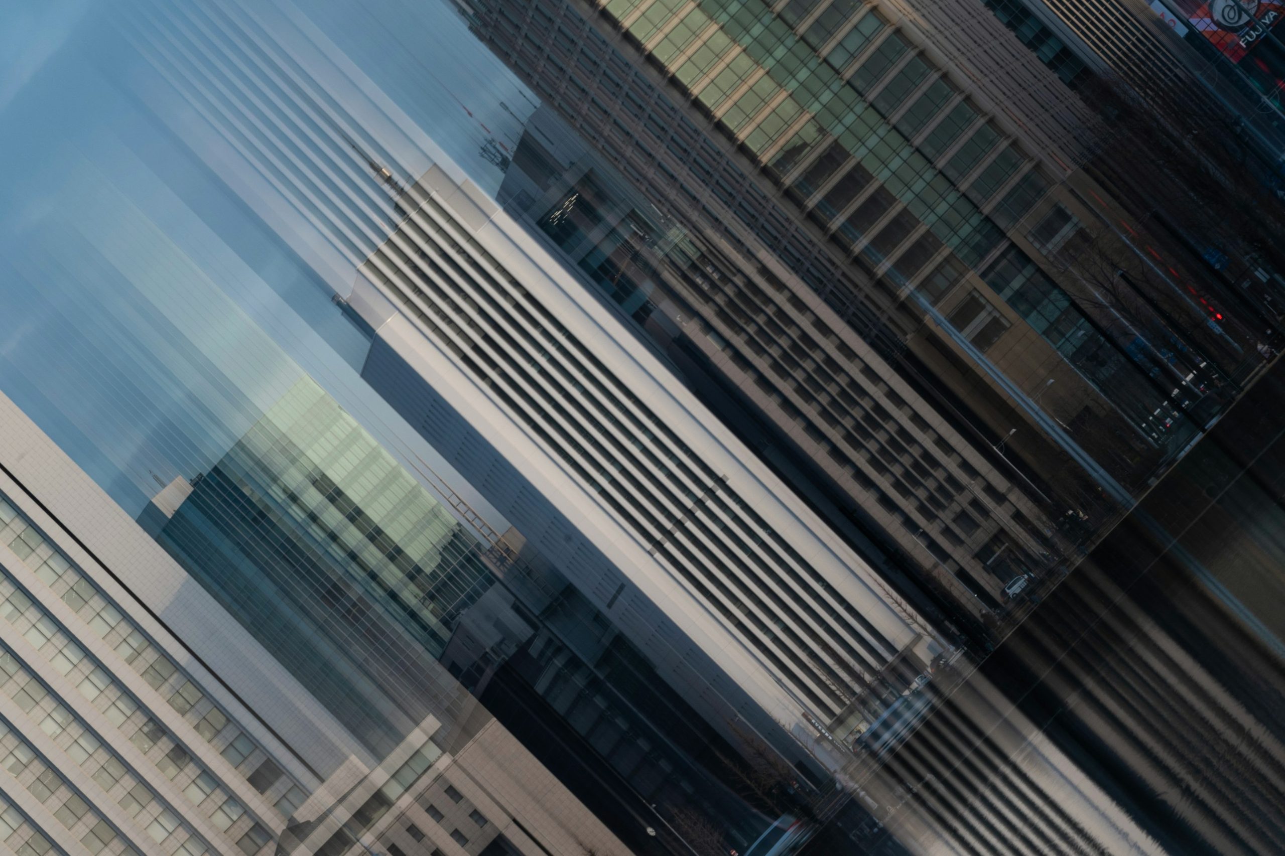 Overlapping high-rise facades form a cool blue geometric abstraction.